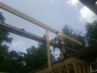 Carpenter setting a ridge beam over a new addition frame — Ice Dam Removal by Roofing Brothers in Aliso Viejo