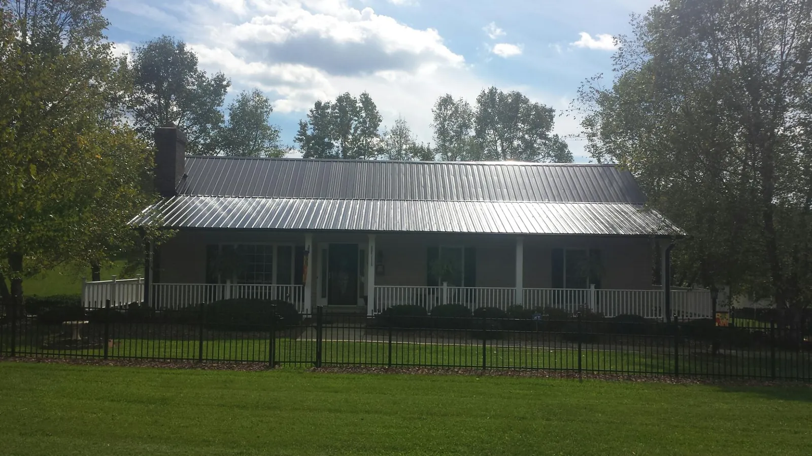 Gray metal roof on a brick ranch with a full width front porch — Gutter Guard Installation work by our crew in Aliso Viejo